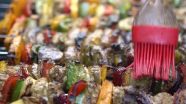 Yavaş Aşçı, sosla kaplanmış mangalda leziz şişler. Izgara et üzerinde brochette pişirmek. Izgara ızgarayla pişirilen yemekler. Dan evinin arka bahçesinde yemek pişiren adam.