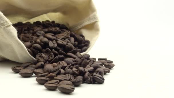 ローストコーヒー豆と4Kの袋は白い背景ダンに回転します — ストック動画