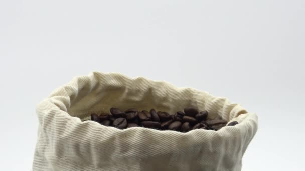 4K烤咖啡豆泡在白色背景的麻袋咖啡里 — 图库视频影像