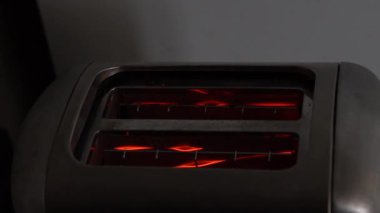 Yavaş ekmek dilimleri, sağlıklı bir kahvaltı modası. Lezzetli tost makinası masada. Elektrikli tost makinesi mutfak atölyesinde, tost makinelerini gösteriyor.