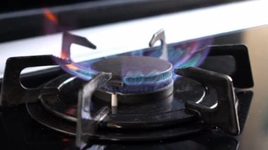 Eski paslı mutfak sobası halkasının yavaş hareketi daha hafif ateşle yandıktan sonra yanar. Mutfak ocağını yakın çekim, alevler, tehlikeli gaz enerjisi ve ev yemekleri kavramı - Dan