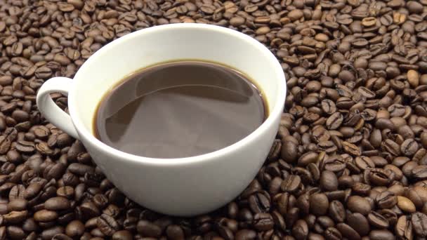 Una Taza Café Negro Sobre Granos Café Tostados Dan — Vídeo de stock