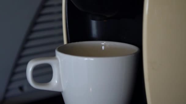 Mouvement lent du café esspresso coulant de la machine à la tasse blanche. Café frais dans la cuisine du restaurant, du bar ou du bureau.-Dan 