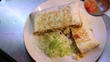 Profesyonel bir aşçı restoranda Meksika yemeği pişiriyor, lezzetli taco ve quesadilla hazırlıyor, peynirli mısır tortilla, domates, marul, tavuk ve sos Dan