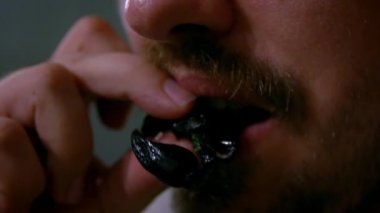 Kamboçya 'daki Asya restoranında akşam yemeği için akrep yiyen beyaz bir erkek. Yakından biri abur cubur yiyor. Turist adam Asya 'da böcekler ile besleniyor. Protein yiyeceği kavramı - Dan