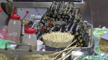 Kore sokak yemekleri çeşit çeşit oden malzemeler, insanlar balık köftesi ve diğer aperatifleri yiyor.