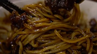 İnsanların Jajangmyeon 'u bir restoranda yemek çubuklarıyla yemesi. Fasulye soslu Kore eriştesi Dan.