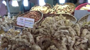 Taipei, Tayvan 24 Mayıs 2015: Tamsui 'deki gece pazarında müşterilere kızarmış mürekkep balığı ve diğer geleneksel balık yemekleri servis eden 4K Asyalı. Tayvan, Taipei 'de çekilmiş. - Dan.
