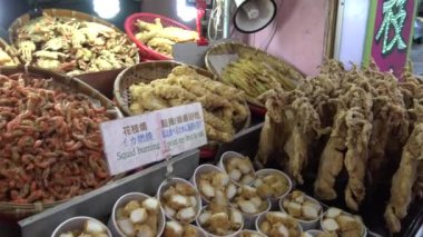 4k Asya gıda standı Tamsui Sokak gece pazarında kızarmış kalamar ve diğer geleneksel balık yemi satar. Taipei, Tayvan 'da çekilmiş.