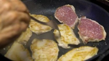 Yavaş hareket eden bir şef mutfakta tavada kızartılmış domuz filetosu pişiriyor. Yavaş yavaş domuz filetosu sağlıklı yaşam yemeği. Lezzetli, ince bir dilim domuz eti. Lezzetli, besleyici organik beslenme
