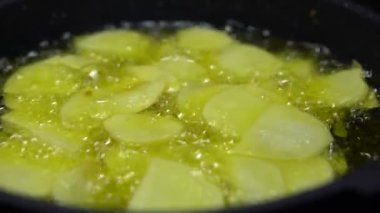 4K, yağda birkaç kabarcık görünene kadar yüksek sıcaklıkta tavada yiyecek kızartma. Patates kızartması. Patates, kaynar yağın içine atılmış. Fast food konsepti, lezzetli yemekler, restoran-Dan...