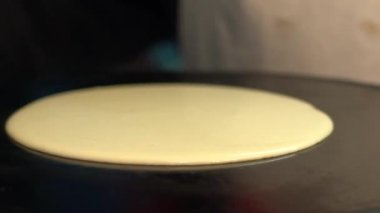 Paris 'teki sokak satıcısında krep pişiren adama yakın çekim. Lezzetli krep tatlısı. Şef, metal bir ızgarada yapılmış krep pişiriyor. Lezzetli fast food konsepti - Dan