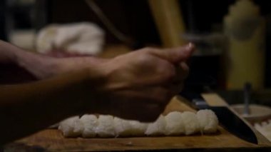 Asyalı şef Japonya 'nın mutfağında suşi yapmak için çiğ balık dilimi hazırla. Japon restoranında yemek yapan bir adam. Satılık leziz Asya yemekleri yapan ellerinizi kapayın.