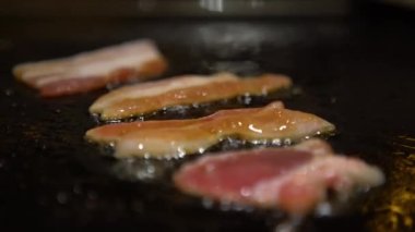 4K Cuisine küçük bir parça domuz bifteği. Bir şef, bir mutfak restoranında ızgarada çiğ domuz eti pişiriyor. Kapalı mekanda pişirilmiş.