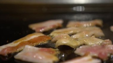 4K Cuisine küçük bir parça domuz bifteği. Bir şef, bir mutfak restoranında ızgarada çiğ domuz eti pişiriyor. Kapalı mekanda pişirilmiş.