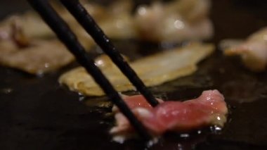 Slow Motion Cuisine küçük bir parça domuz bifteği. Bir şef, bir mutfak restoranında ızgarada çiğ domuz eti pişiriyor. Kapalı alanda pişirilmiş 120 fps-Dan Slow Motion oranı
