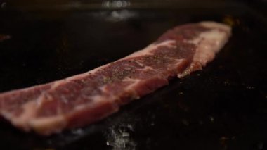 4K Cuisine biftek. Bir şef, bir mutfak restoranında çiğ et bifteği pişiriyor. Kapalı mekanda yakın plan Dan