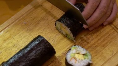 Makizushi 'nin Yavaş Hareketi hazırlanıyor. Ev yapımı suşi ve ekmek yapma süreci. Erkek aşçının eli bıçakla kesilirken, evde ya da restoranda mutfak masasında, Dan masasında.
