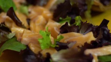 Ahşap tabakta servis edilen yeşil sebze yapraklı lezzetli somon kesesi. Restoranda geleneksel Japon yemekleri.