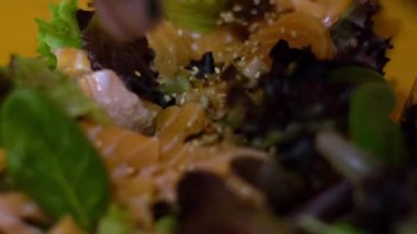 Somon kesesi hazırlanırken yavaş hareket ediyor. Kadın şefin elleri mutfaktaki restoranda geleneksel Japon yemeklerini hazırlıyor. Ev yapımı Dan 'de ahşap masada ev yapımı suşi yapmak.