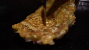 4K Okonomiyaki Japon yemeği. Çeşitli malzemeler içeren krep, hamurlu, un ve sudan yapılmış, doğranmış lahana, yumurta, soğan ve deniz ürünleri. Monjayaki 'yi Japon restoranında kızartıyorlar. Dan.