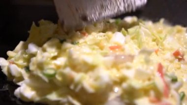 Slow Motion Okonomiyaki Japon yemekleri. Çeşitli malzemeler içeren krep, hamurlu, un ve sudan yapılmış, doğranmış lahana, yumurta, soğan ve deniz ürünleri. Japonya 'da Monjayaki' yi pişir - Dan Restoranı