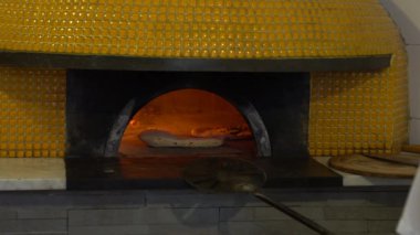 Şef 'in yeni İtalyan calzone' sini geleneksel ahşap yakılmış taş fırına koyması yavaş bir hareket. Maya hamuru fırında pişirilir ve fırında artar. Geleneksel pizza pişirme, İtalya-Dan kırsal mutfağı