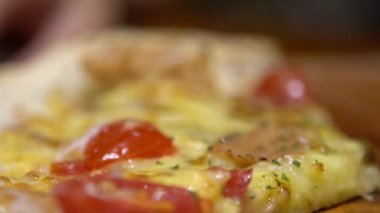Asyalı kadın yavaş çekimde erimiş peynirli sıcak pizzayı yemeye hazır hale getiriyor. İtalyan restoranındaki lezzetli organik fast food pizzalarına yakın çekim.