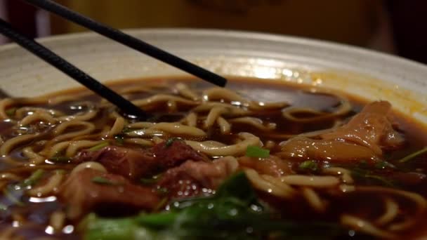 遅いアジアの女性の動きは レストランで夕食のための牛肉麺を食べる 熱い伝統的な中国料理 ダンを食べるための棒を使用して — ストック動画