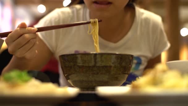 4Kアジアの女性がレストランで夕食に牛肉麺を食べています 熱い伝統的な中国料理 ダンを食べるための棒を使用して — ストック動画