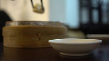 Restoranda soya sosuna 4K hamur tatlısı batırmak. Tayvan 'da Çin yemeği olarak servis edilen Çin yemeğini ye. Küçük buharlı sepetlerde servis edilen küçük lokma büyüklüğünde yiyecekler olarak hazırlandı.