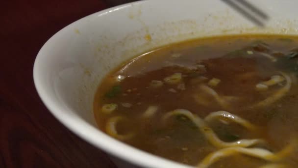 4K people eating a bowl of beef noodles for dinner in an asian restaurant. Using sticks for eat the hot traditional chinese food in Taiwan.-Dan — Stock Footage People Eating Bowl Beef Noodles Dinner Asian Restaurant Using Sticks Royalty Free Stock Footage