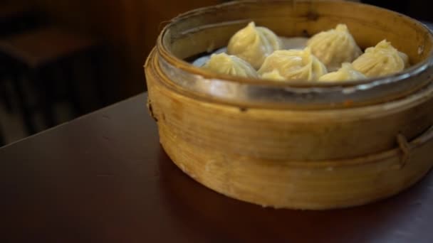 4Kレストランでの餃子の皿 台湾では伝統的な中華料理が薄暗かった 小蒸し籠段で提供される食品の小さな一口サイズの部分として調製 — ストック動画