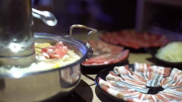 ドーナツ型の真鍮鍋と伝統的な北京スタイルの中国の鍋 ダイニングテーブル 生の新鮮な食材 中国で有名な銅瓶鍋でおいしい牛肉 フードコンセプト — ストック動画