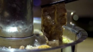 Çin 'de pirinç çömlek şeklinde bir çömlekle ağır ateşte pişirme hareketi. Pekin 'de çok popüler olan Çin yemeği. İnce dilimlenmiş et ve sebzeler suda kaynatıldı ve malzemeler karıştırıldı.