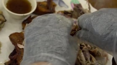 Tayvan Dağında geleneksel tavuk yemeği hazırlayan şefin yakın çekimi. Çamur fırınında ünlü kızarmış tavuk. Asyalı bir adam yemek yemek için eldiven kullanıyor.