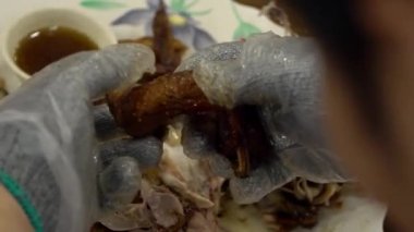 Yavaş Aşçı Hareketi Tayvan Dağında geleneksel tavuk yemeği hazırlıyor. Çamur fırınında ünlü kızarmış tavuk. Asyalı bir adam yemek yemek için eldiven kullanıyor.