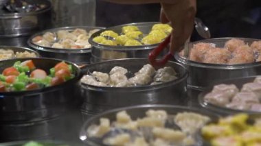 Yavaş çekim satıcısı Shaomai 'yi hazırlıyor ve satıyor ve Tayvan' daki Asya Caddesi Gıda Pazarı 'nda müşterileri var. Hamur köftesi, Oriental Night Market 'te geleneksel Çin yemeğidir. Şehir merkezindeki restoran.
