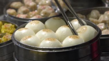 Yavaş çekim satıcısı Shaomai 'yi hazırlıyor ve satıyor ve Tayvan' daki Asya Caddesi Gıda Pazarı 'nda müşterileri var. Hamur köftesi, Oriental Night Market 'te geleneksel Çin yemeğidir. Şehir merkezindeki restoran.