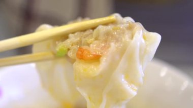 Yavaş çekimde insanlar Asya restoranında karides köftesi yiyorlar. Tayvan 'da geleneksel Çin yemeklerini yemek için çubuk kullanıyorlar. Aslen Çin 'den. - Dan.