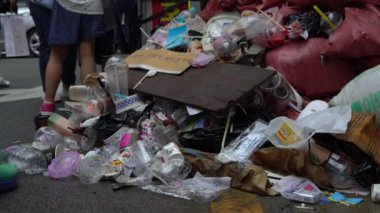 Güney Kore, Busan 'daki şehir sokaklarında arka planda insanlar olan 4K Trash kaldırımında. Çöp, Çöplük, Paketler, Atık, Kirlilik-Dan