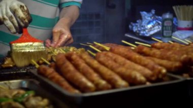 Slow Motion Sendor, şişte Tayvan tavuğu pişiriyor. Çelik ızgara gece marketi sokağı. İnsanlar et ızgara barbekü yaptı. Lezzetli fast food Asya. Geleneksel Çin yemeği çubukta. Asya oyalaması - Dan