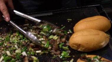 Slow Motion Sendor, Tayvan usulü domuz etini gece pazarında ızgarada pişiriyor. İnsanlar popüler et ızgara barbekü pişirdi. Lezzetli yemekleri olan ünlü bir pazar yeri. Asyalı tezgahında Çin yemeği.