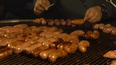Yemek standında barbekü sosisi ızgara yapan tezgahtarın yavaş çekimi. Tainan şehrinin Gece Pazarı 'nda nefis bir sosis. Tayvan 'ın yerel sokak atıştırmalıkları. Tayvan-Dan 'de popüler pazar