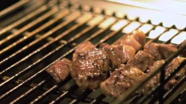 Taipei 'nin Asya Gece Pazarı caddesinde et ızgarasında et pişiren bir tedarikçinin yavaş çekimi. Eti kömürle pişirdim. 120 fps-Dan oranında yavaş.