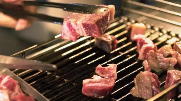 台北亚洲夜市街上 一个供应商在钢制烤架上烤牛肉片 动作缓慢 用剪刀把肉切成小块 然后把肉煮熟 120 Fps Dan的慢速 — 图库视频影像
