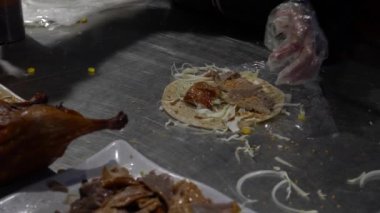 Slow Motion Asyalı kadın meşhur ördek yemeği Pekin 'i hazırlıyor. Et, soğanlı kızarmış deri, taze soğan, salatalık ve sos Çin krepinin etrafına sarılmış. Lezzetli dürüm yapıyorum. Dan.