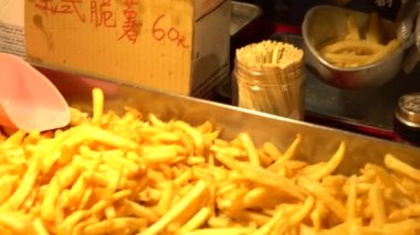 Asyalı bir satıcının 4K 'sı kızarmış patates satıyor. Taipei 'deki Asia Night Market' te popüler bir yemek. Tayvan. - Dan.