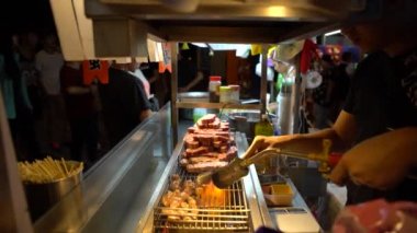 Taipei, Tayvan-10 Şubat 2016: 4k Vendor Taipei 'nin Asya Gece Pazarı caddesinde çelik ızgarada pürmüz ile et parçaları pişiriyor. Eti gaz ocağı ve kömür ocağında pişirdim.