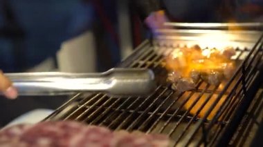 4k Sendor, Taipei 'nin Asya Gece Pazarı sokağında çelik ızgarada pürmüz ile et parçaları pişiriyor. Eti gaz ocağı ve kömür ocağında pişirdim.